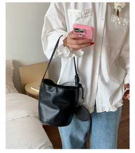 Detail einer schwarzen PU-Zylindertasche mit passender runder Mini-Münztasche