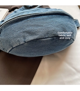 Detailed view of washed blue denim texture and stitching on a stylish crossbody bag