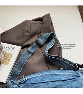 Detail of adjustable black strap on blue washed denim crossbody bag for women