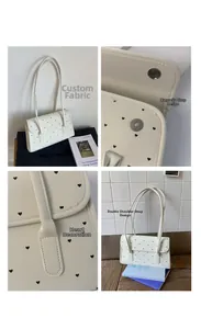Detail view of beige heart-patterned shoulder bag featuring magnetic closure and fabric texture