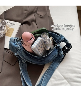 Spacious interior of denim crossbody bag showing storage for umbrella and cosmetics