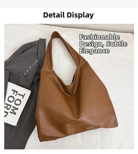 Detail view of large brown faux leather tote bag with soft hobo design on white fabric