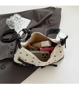 Detail view of the spacious inner compartment of this quilted cream shoulder bag
