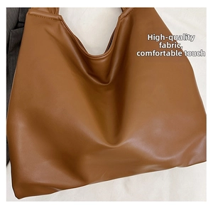 Close-up of premium brown leather texture on a spacious tote bag with soft finish