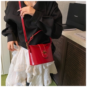 Detail der roten Lackleder-Beuteltasche mit elegantem Goldverschluss und Riemen