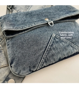Close-up of washed denim canvas bag showing twill fabric texture and white stitching details