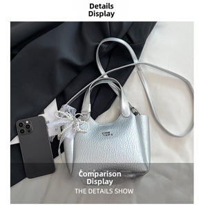 Detail of silver textured leather bucket bag with decorative pearl and lace charms