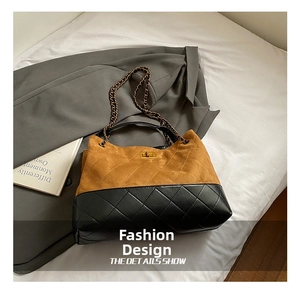 Détail d'un sac cabas marron matelassé avec fermoir doré et bandoulière sur lin blanc