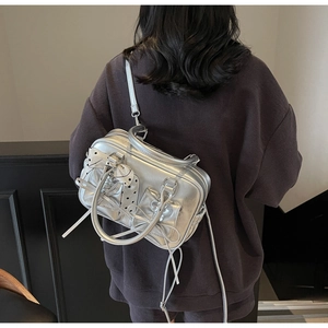 Borsa a tracolla argentata Y2K con fiocchi mostrata su modella per effetto di taglia