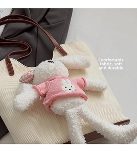 Dettaglio di un coniglio di peluche bianco con maglione rosa per borse tote moda