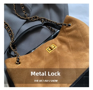 Détail du sac cabas en daim vintage avec fermoir doré et texture de bandoulière chaîne