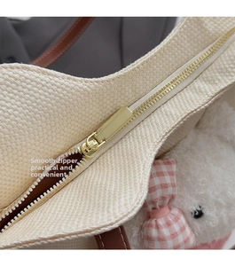 Dettaglio della cerniera dorata e della trama intrecciata con peluche sulla borsa