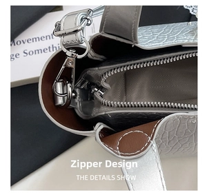 Detail showing the silver metallic crackle leather texture and sturdy zipper closure