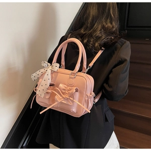 Zaino in pelle verniciata rosa con grande fiocco e nastro a pois indossato dalla modella