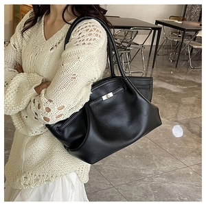 Chic black tote bag with lychee grain leather and metal clasp shown on model
