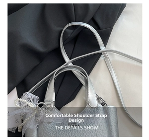 Detail of silver metallic textured bucket bag with lace and pearl pendant accessories