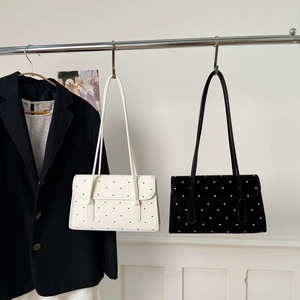 Detailed close-up of retro polka dot underarm bags in black and white with heart patterns
