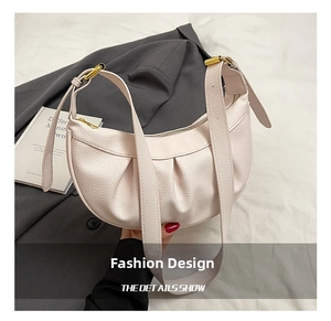 Détail du sac hobo crème en cuir grainé avec boucle dorée et design plissé