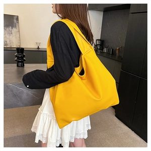 Fashionable bright yellow oversized tote bag styled on model in modern minimalist setting
