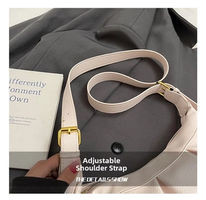 Détail de la bandoulière réglable avec boucle en métal doré sur le sac en cuir beige