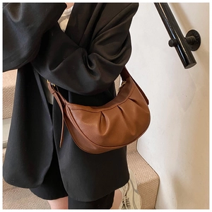 Détail du sac bandoulière marron en cuir grainé avec un design plissé élégant