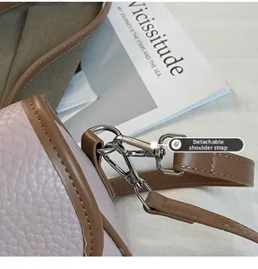 Macro shot of silver metal hook and pink lychee leather with detachable strap
