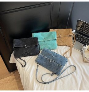 Flat lay of vintage denim crossbody bags in four colors with magnetic metal buckles