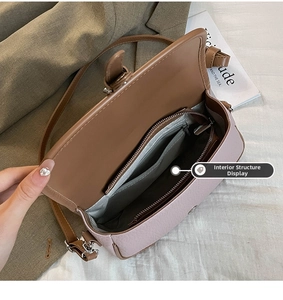 Detail view of the interior layout with a zipper pocket and striped lining in a small bag