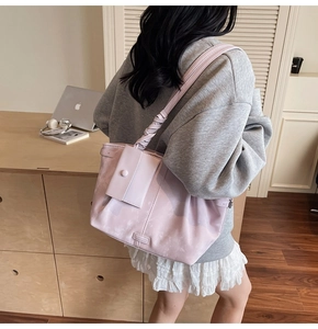 Detalle del bolso tote rosa claro con asa trenzada y pequeño estuche de accesorio