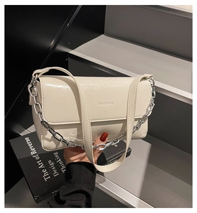 Detailed macro view of the off-white chain baguette bag with polished glossy finish