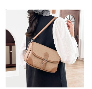 Detail view of camel lychee pattern leather shoulder bag on a model's arm for daily use