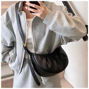 Détail du sac demi-lune en cuir grainé noir avec bandoulière réglable et boucle dorée