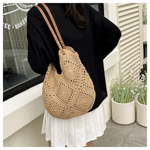 Detail of hollow sunflower woven straw bag with premium brown leather shoulder strap