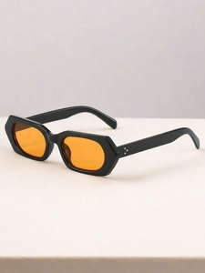 Close-up of retro hexagonal sunglasses with black frames and orange lenses and rivets