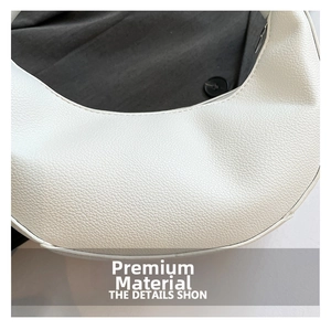 Close-up of premium white lychee grain leather texture and precise stitching on handbag