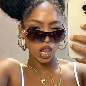 Detail shot of oversized Y2K sunglasses with gradient lenses and large gold hoop earrings
