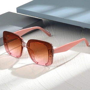 Détail de lunettes de soleil carrées à paillettes avec verres dégradés orange rose