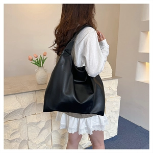 Detail of minimalist black large tote bag made of soft PU leather on a modern display counter
