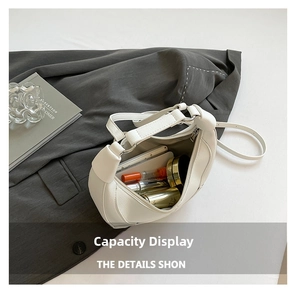 Detailed view of white crescent bag interior showing spacious capacity for cosmetics