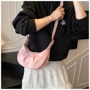 Sac hobo rose avec texture plissée et bandoulière réglable porté par un mannequin