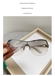 Close-up of Y2K square sunglasses with gradient grey lenses and gold metal hinge details