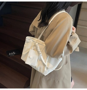 Vista detallada del bolso tote blanco grande con asas largas y un pequeño bolso a juego