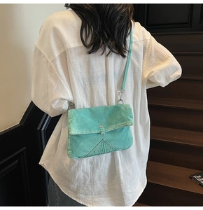 Détail de la bandoulière en denim vert menthe montrant les coutures sur toile lavée