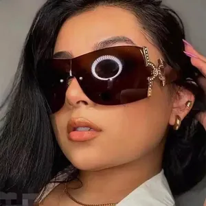 Close-up of frameless Y2K oversized sunglasses with luxury gold rhinestone temple detail