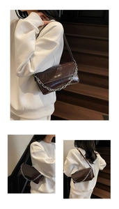 Detail of dark brown baguette bag with glossy crinkled leather and thick silver chain