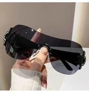 Close-up of luxury Y2K rimless sunglasses featuring sparkling rhinestone details on the side