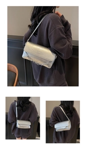 Detailed view of silver baguette bag with crinkle texture and chunky chain strap
