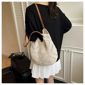 Detail of cream crochet shoulder bag with hollow diamond pattern and brown leather strap