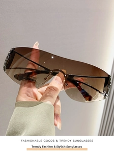 Détail de lunettes de soleil sans monture dégradé marron avec bords ornés de strass brillants