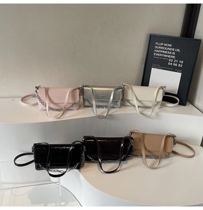 Detailed view of glossy leather crossbody bags in six vibrant colors with silver chains